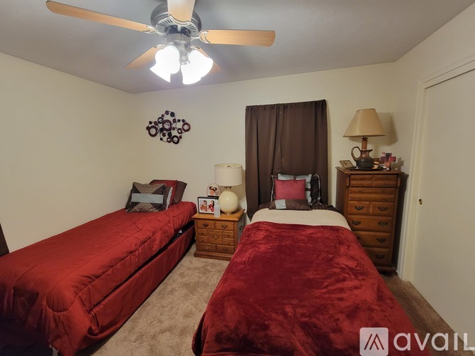 A bedroom with two beds and a ceiling fan.