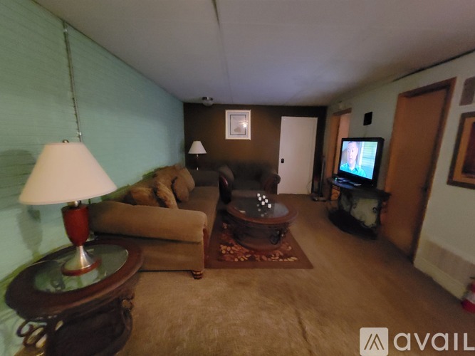 A living room with a couch, a coffee table, and a television.
