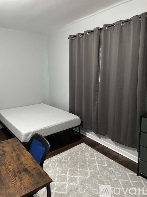 A room with a bed, a chair, and a table.