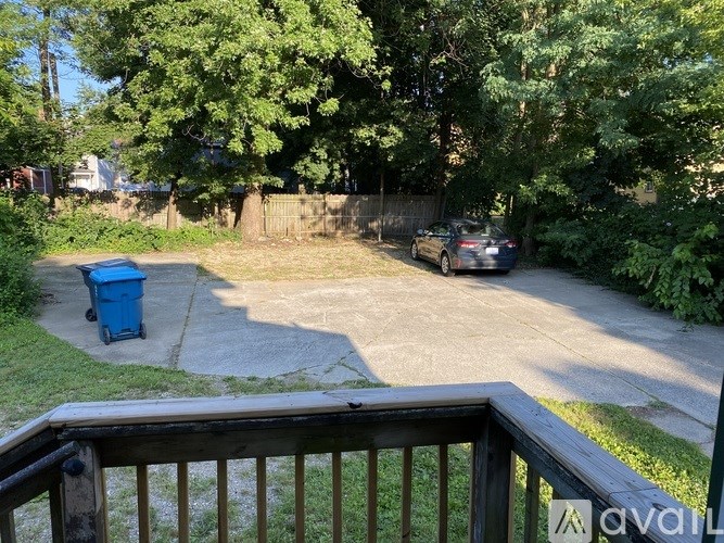 A car is parked in a driveway surrounded by trees.
