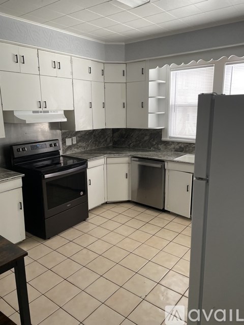 A kitchen with white cabinets and a black stove top oven.