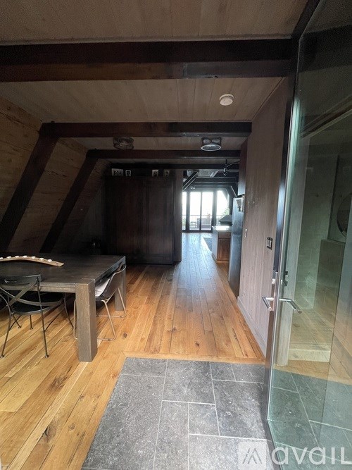 A room with wooden floors and a table with chairs.