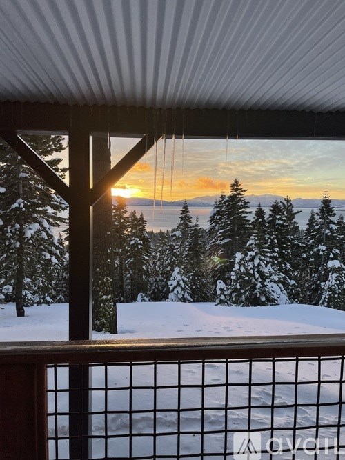 A snowy landscape with trees and a sunset.