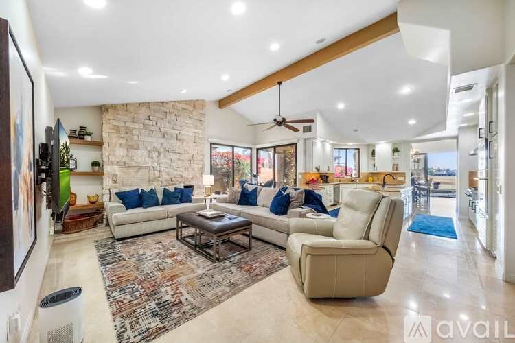 A spacious living room with a stone wall and a large sectional sofa.
