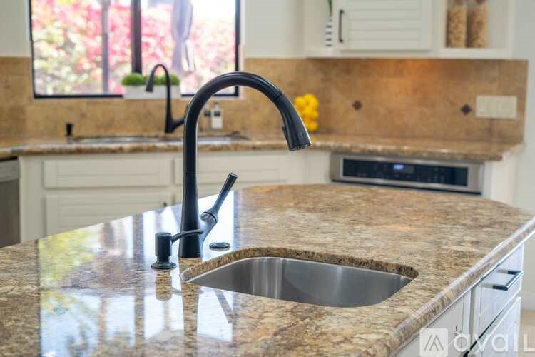 A kitchen with a granite countertop and a modern faucet.