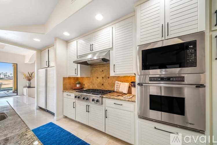A modern kitchen with white cabinets and stainless steel appliances.