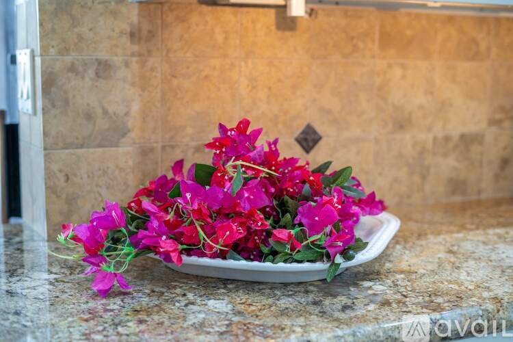 A bouquet of pink flowers is sitting on a marble countertop.