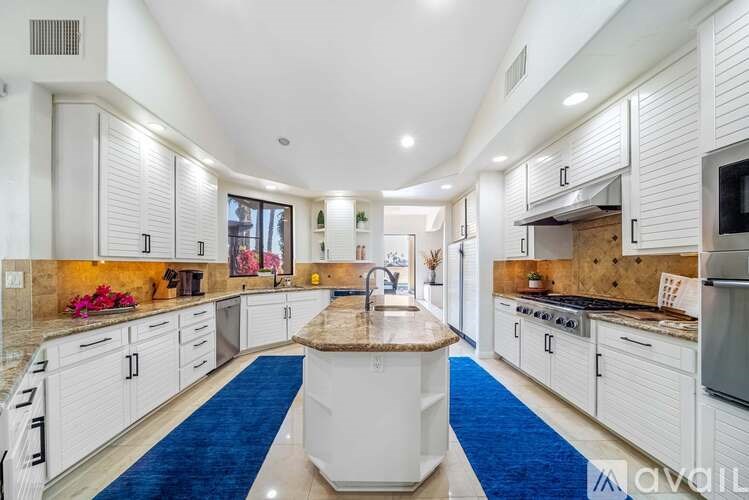 A modern kitchen with white cabinets and a central island.
