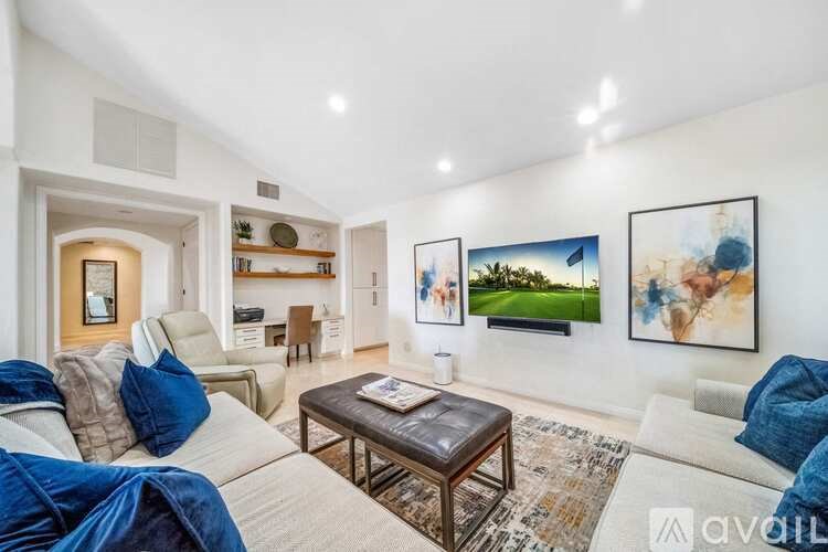 A living room with a white couch and a brown coffee table.