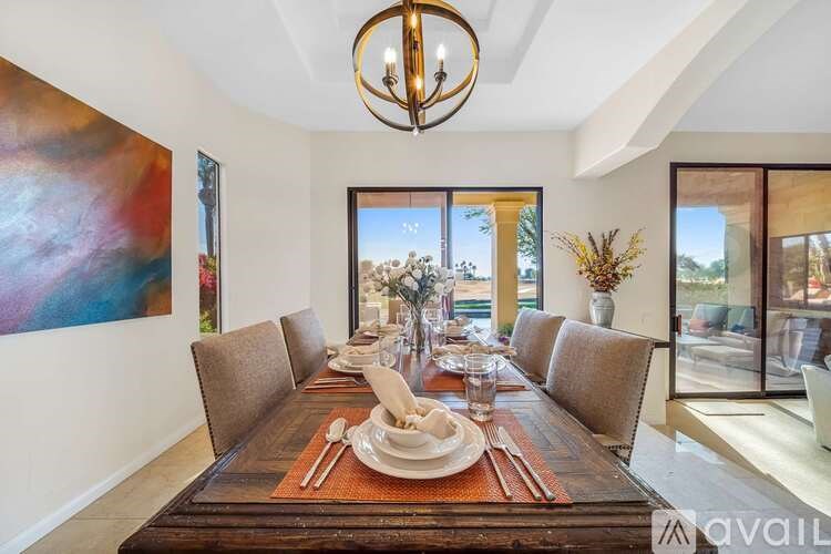 A dining room with a long table set for a meal.