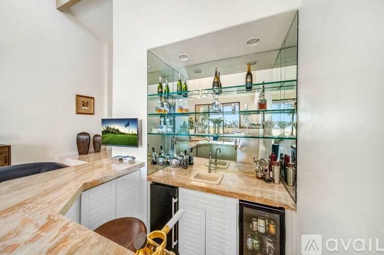 A kitchen with a wooden countertop and a glass-fronted cabinet.