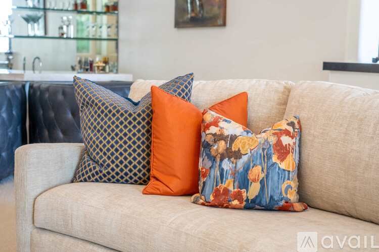 Three decorative pillows on a beige couch.