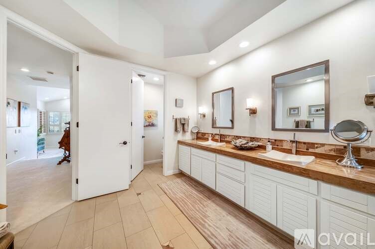 A bathroom with a white door and a mirror on the wall.