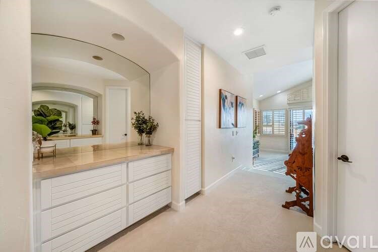A spacious kitchen with white cabinets and a countertop.