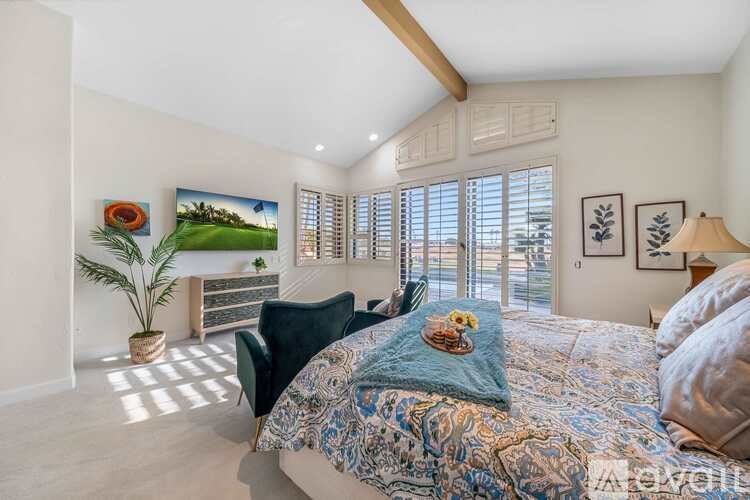 A bedroom with a large bed and a view of the outside through the window.