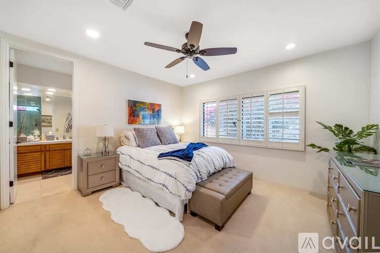 A bedroom with a bed, nightstand, and a ceiling fan.