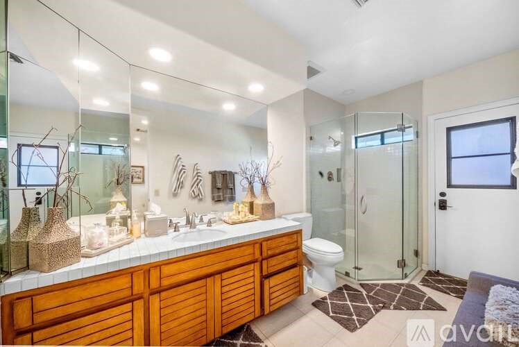 A bathroom with a wooden vanity and a walk-in shower.