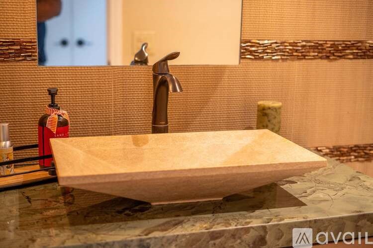 A bathroom sink with a marble countertop and a mirror above it.