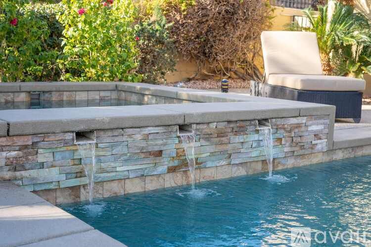 A pool with a waterfall feature in the middle of it.
