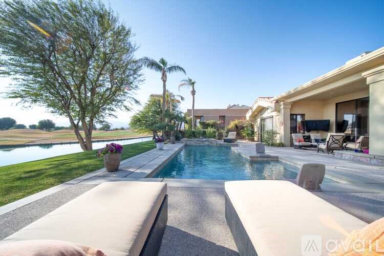 A person is sitting on a bench by a pool.