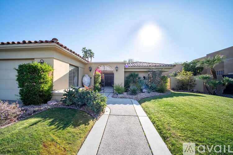 A house with a well-maintained lawn and a clear sky above.