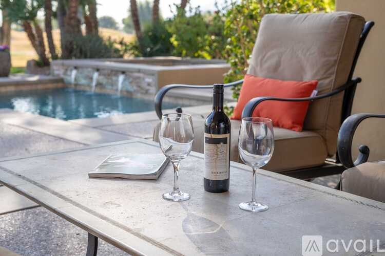 A table with a bottle of wine and two glasses on it.