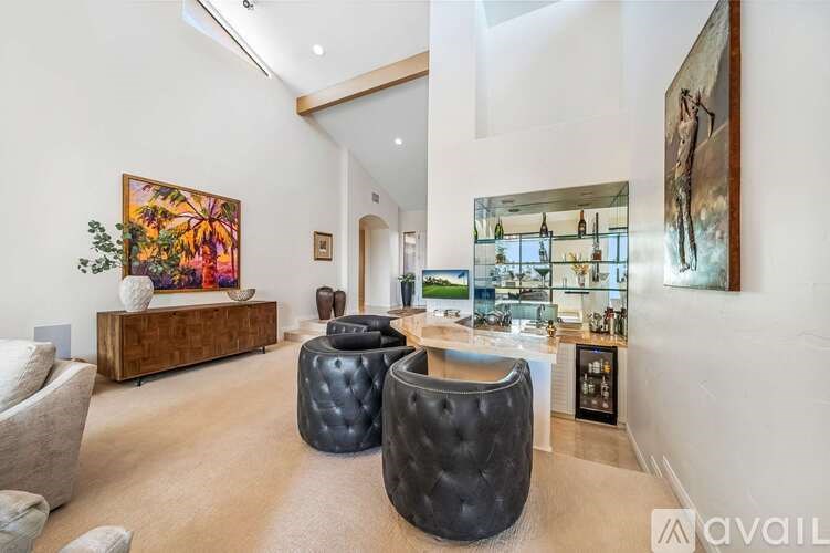 A living room with a large painting on the wall and a wooden cabinet.