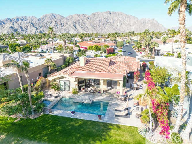 A house with a pool and mountains in the background.