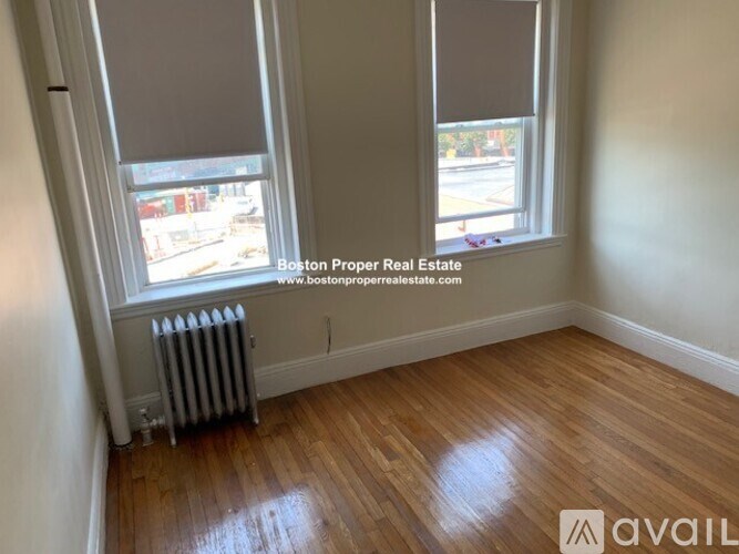 A room with wooden floors and two windows.