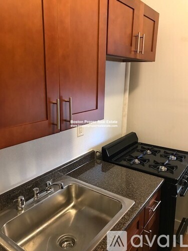 A kitchen with wooden cabinets and a stove top oven.
