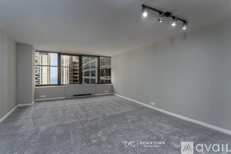 A spacious empty room with a view of the cityscape outside the large windows.