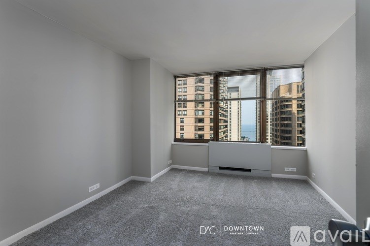 A spacious, empty room with a large window overlooking a cityscape.