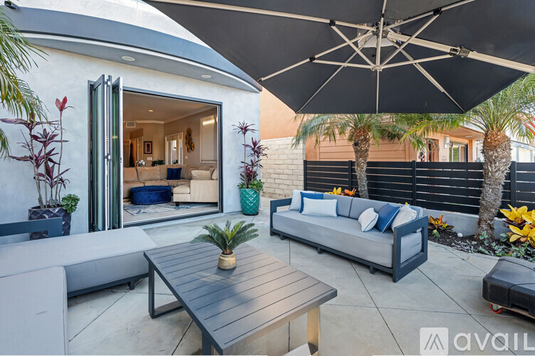 A patio with a table and chairs under an umbrella.
