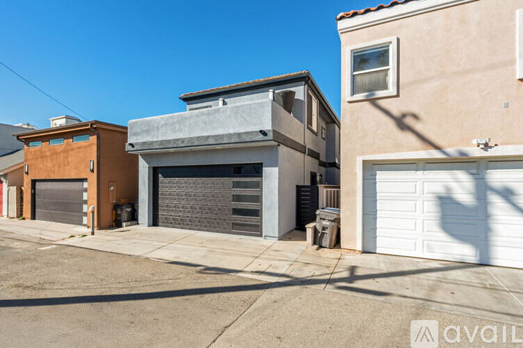 A two-story building with a garage door is situated between two other buildings.