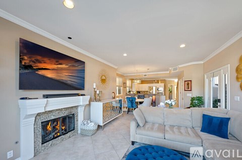 A living room with a fireplace and a painting on the wall.