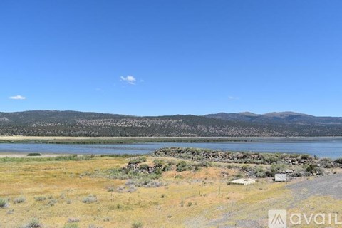 A landscape with a lake, mountains and a clear sky.
