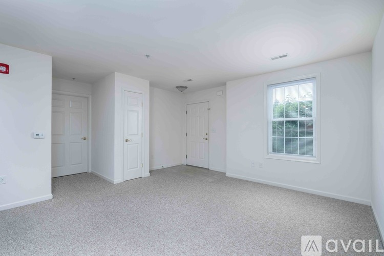A large empty room with a carpeted floor and white walls.