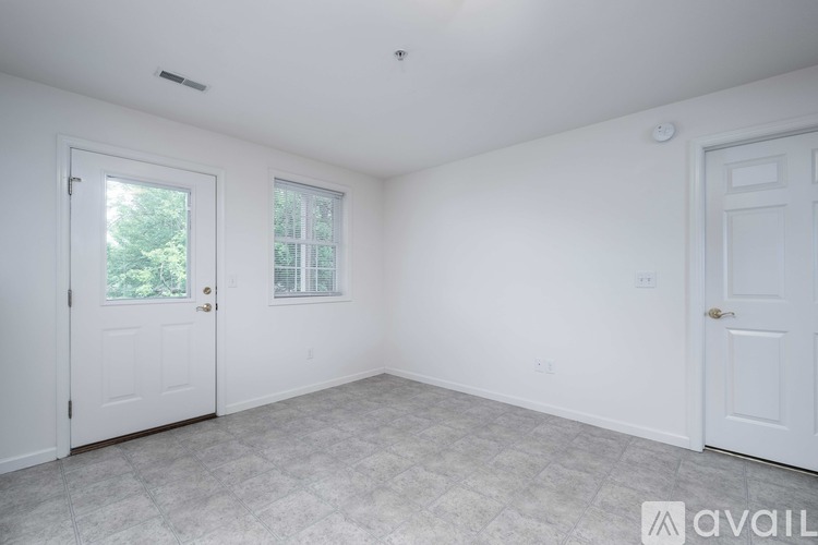 A room with a window and carpeted floor.