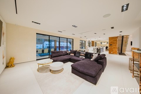 A living room with a purple couch and a white coffee table.