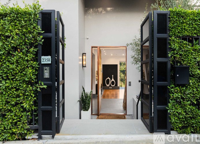 A modern house entrance with a glass door and a wooden floor.