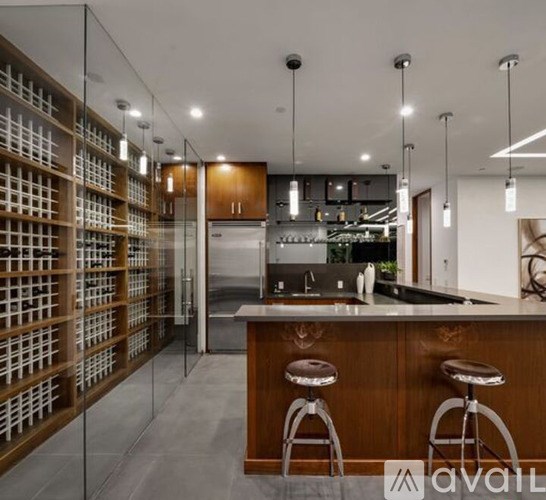 A modern kitchen with a bar area and a wine rack.