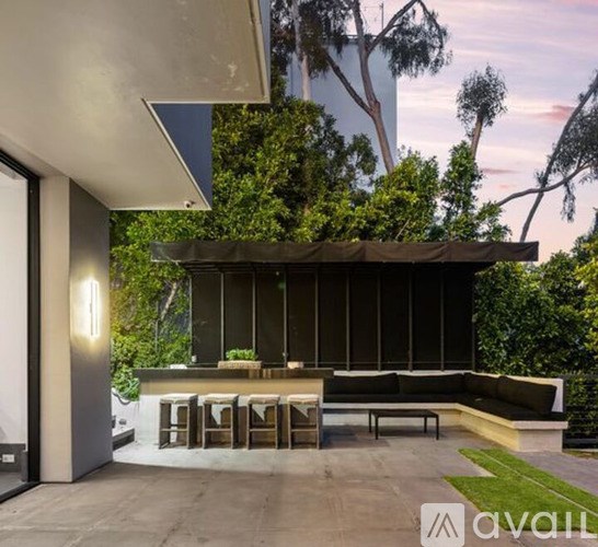A modern outdoor seating area with a glass wall and a bench.