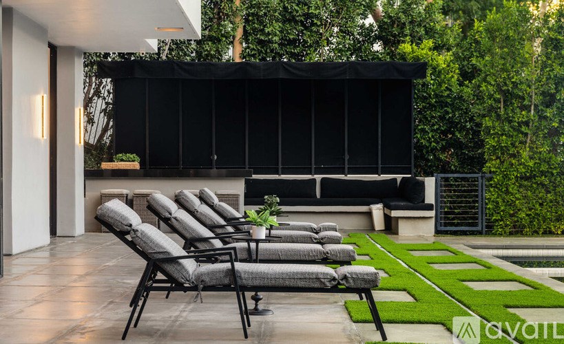 A patio with black chairs and a black screen.
