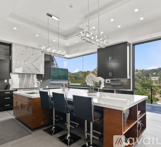 A modern kitchen with a large island and a view of the outdoors.