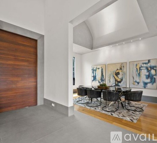 A modern dining room with a wooden table and chairs.