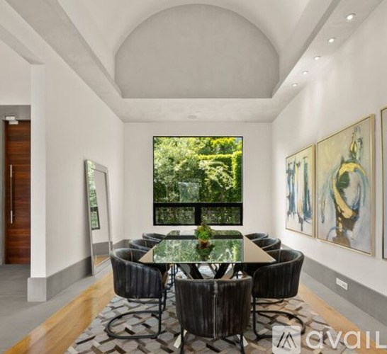 A modern dining room with a glass table and chairs.