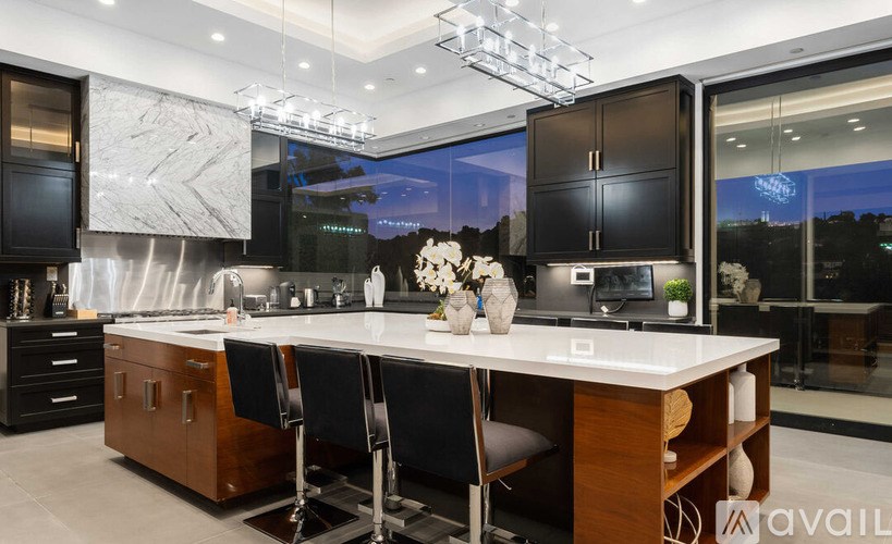 A modern kitchen with a marble backsplash and a large island.