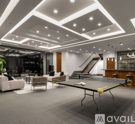 A spacious living room with a ping pong table in the center.