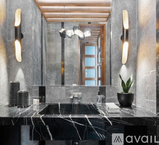 A bathroom with a marble countertop and a large mirror.