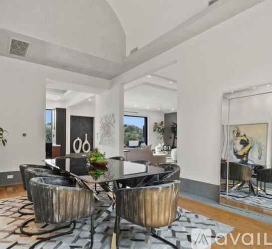 A modern dining room with a glass table and chairs.